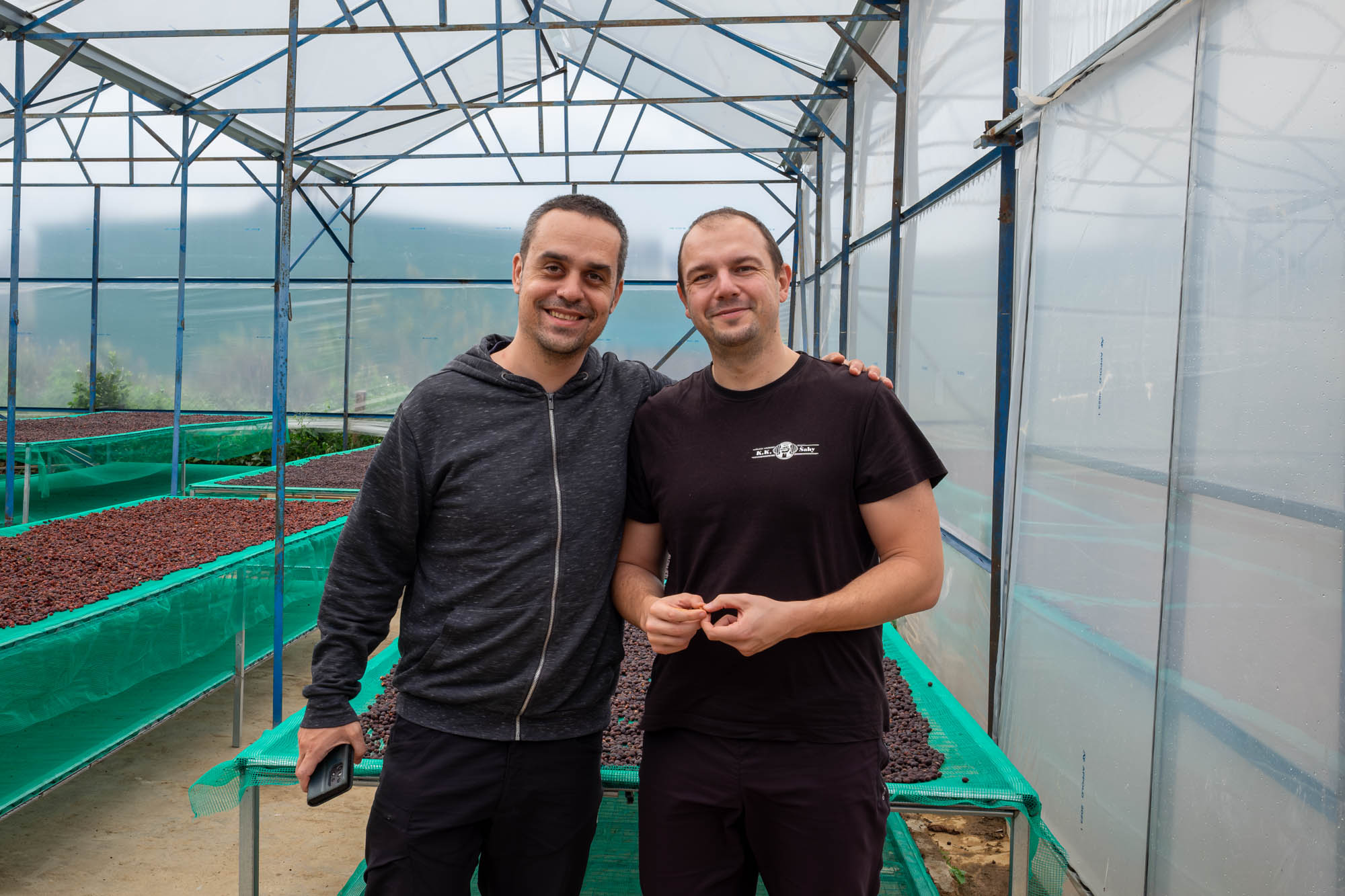 Petr a Martin u kávových zrn schnoucích na afrických postelích na vietnamské farmě
